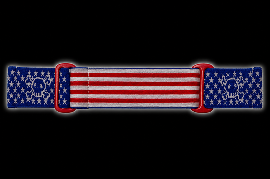 JT Flex paintball goggle strap featuring an American flag design with a GREED twist. Featuring red and white stripes, blue star panels, woven skull graphics, and red adjustment loops.